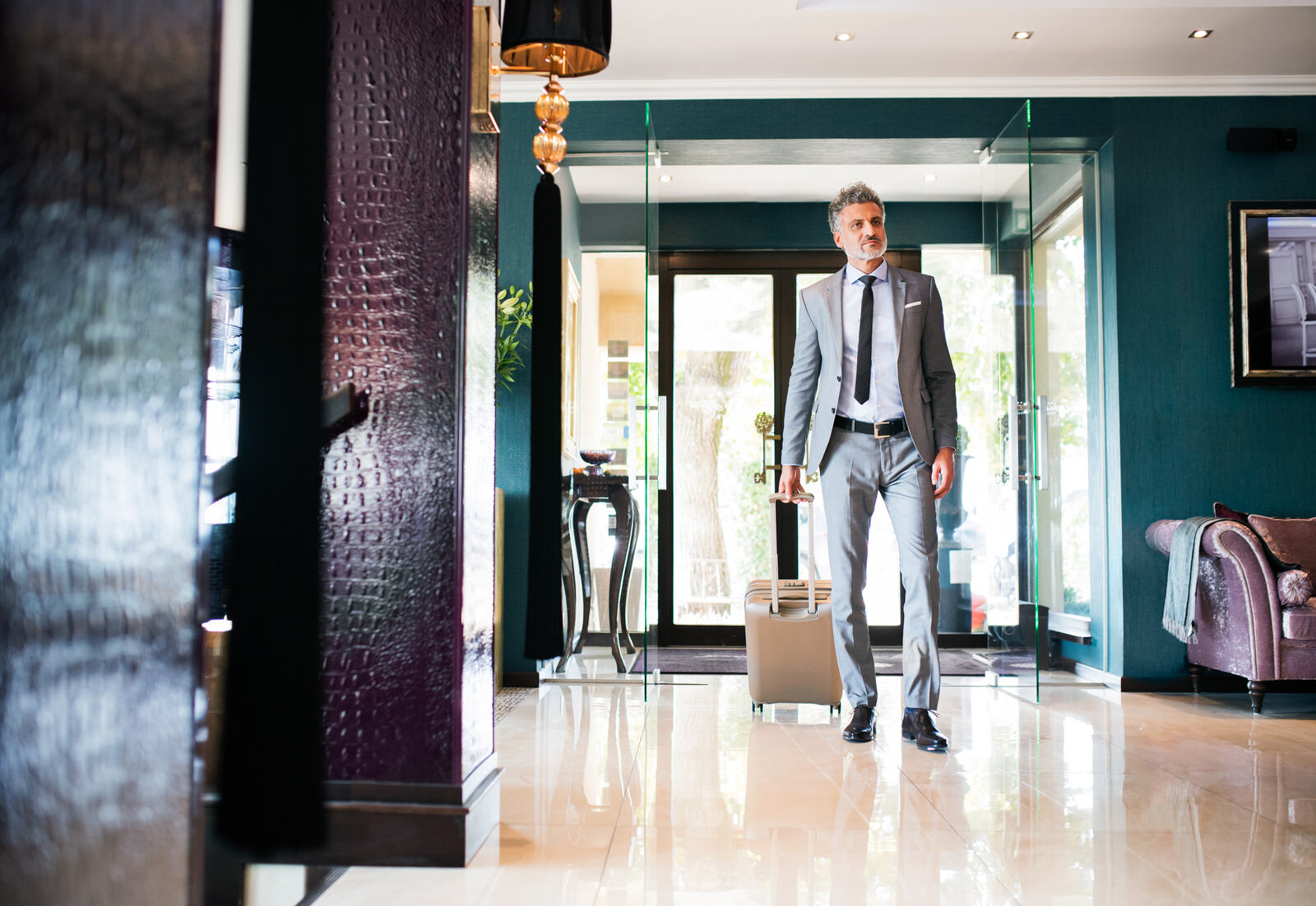 Executive arriving at his hotel lobby with a suitcase