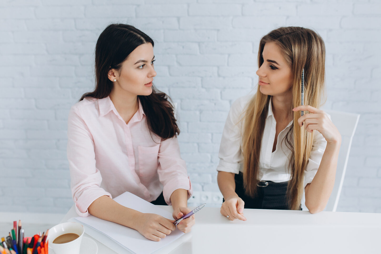 Executive in a one-on-one language lesson with her teacher in a bright office