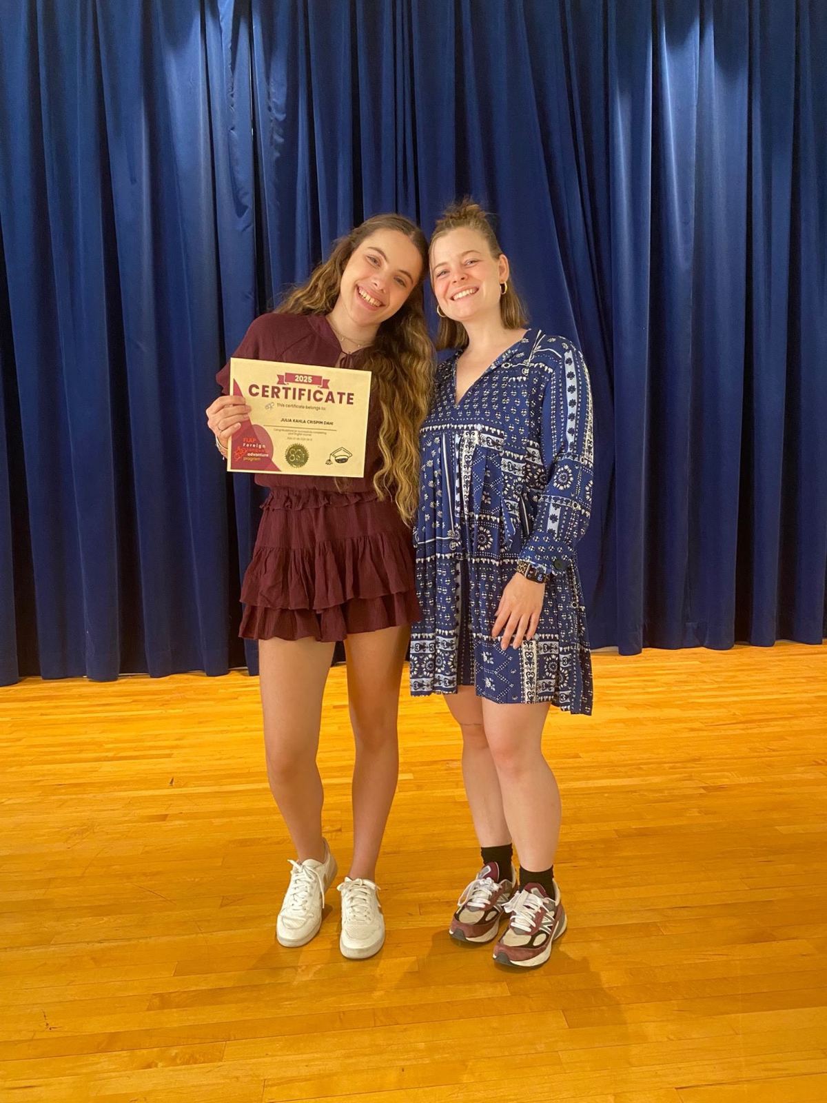 Two campers on stage presenting with a certificate at the end of camp